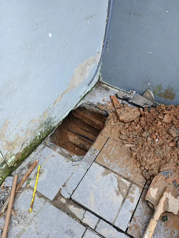 Abertura no piso junto ao canto de uma parede.